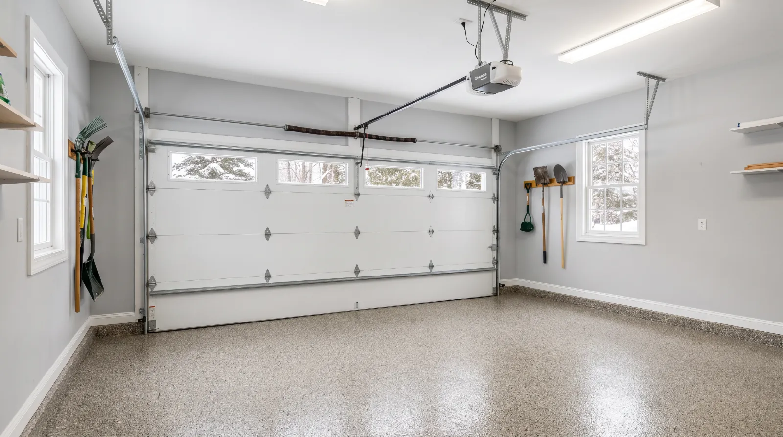 Attached two-car garage with a white insulated steel door, a torsion spring above it and a belt-drive opener on the ceiling